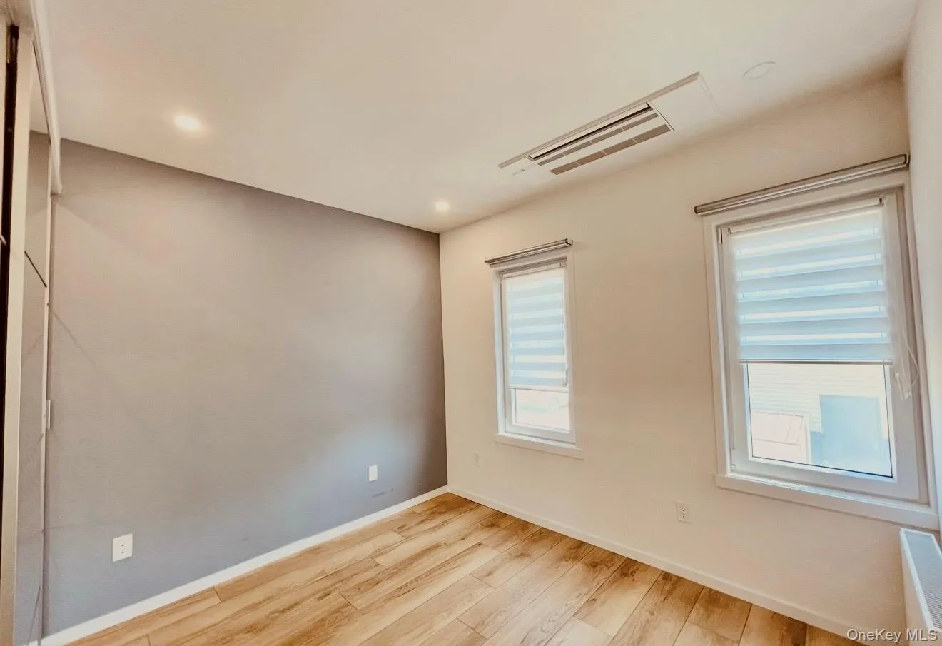 Empty room with light wood finished floors and recessed lighting Empty room with light wood finished floors and recessed lighting