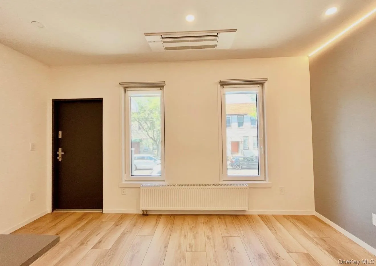 Spare room with radiator, plenty of natural light, cooling unit, light wood-style flooring, and recessed lighting Spare room with radiator, plenty of natural light, cooling unit, light wood-style flooring, and recessed lighting
