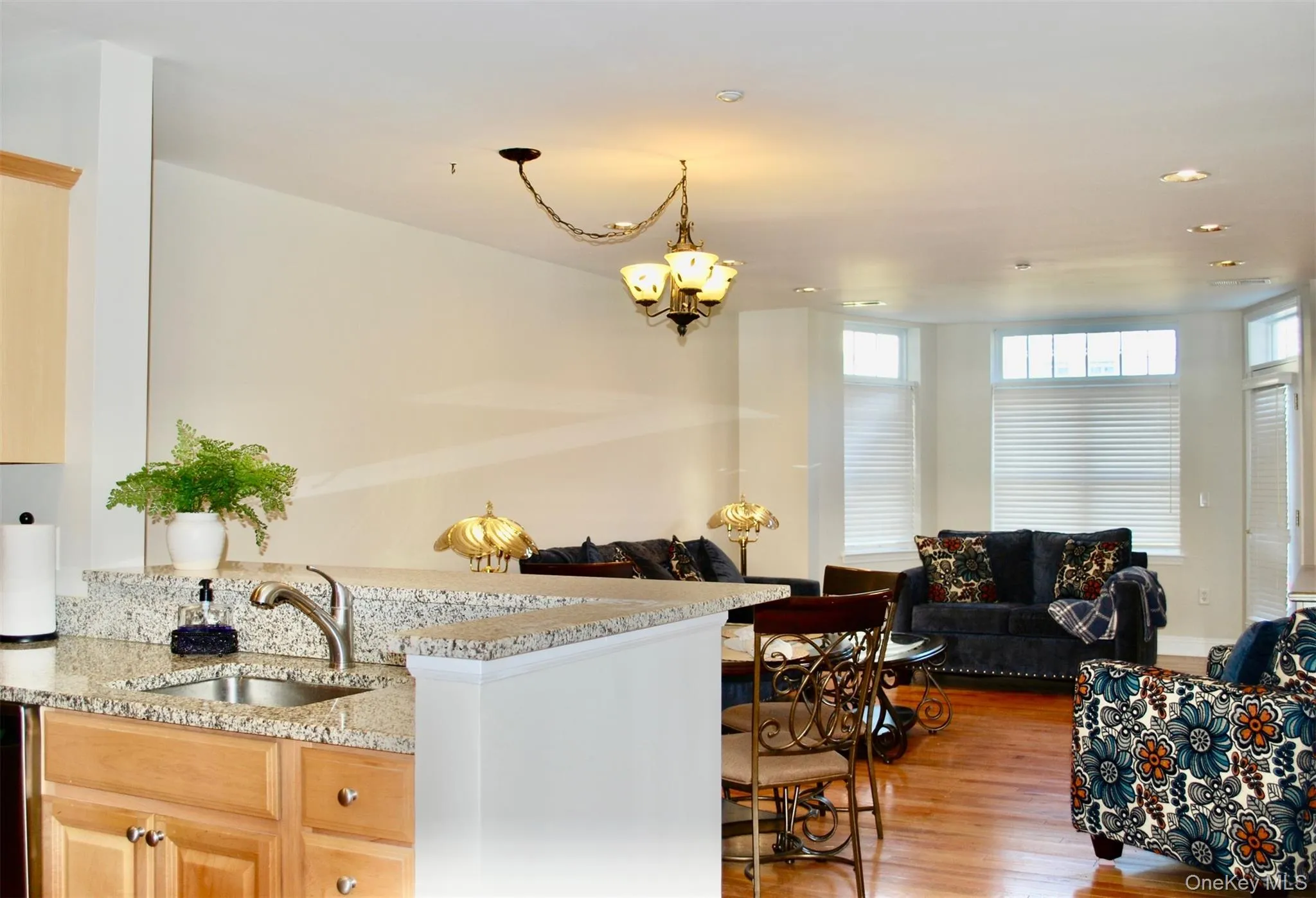 Kitchen featuring open floor plan, light stone countertops, light wood-type flooring, recessed lighting, and light brown cabinets Kitchen featuring open floor plan, light stone countertops, light wood-type flooring, recessed lighting, and light brown cabinets