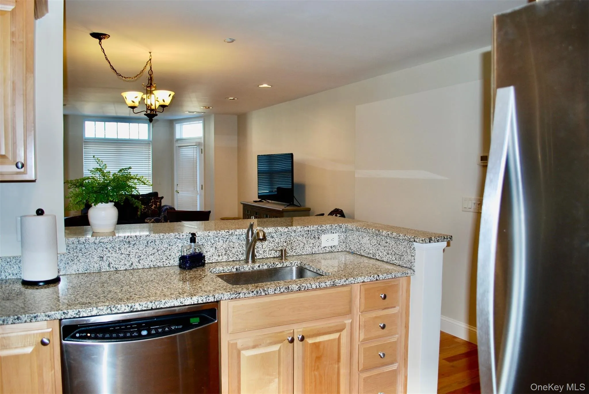 Kitchen with stainless steel appliances, a peninsula, light stone countertops, recessed lighting, and open floor plan Kitchen with stainless steel appliances, a peninsula, light stone countertops, recessed lighting, and open floor plan