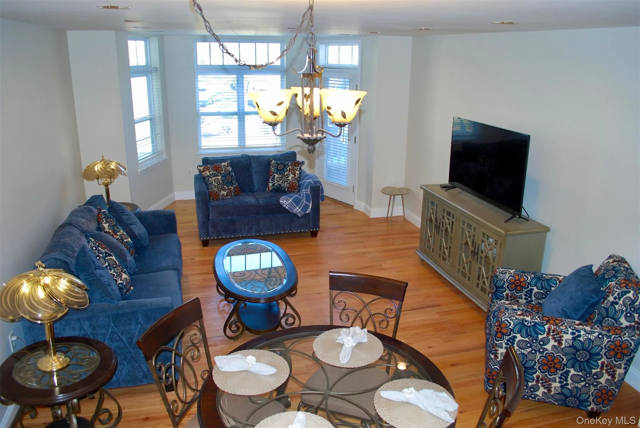 Living room featuring light wood-style flooring and a chandelier Living room featuring light wood-style flooring and a chandelier