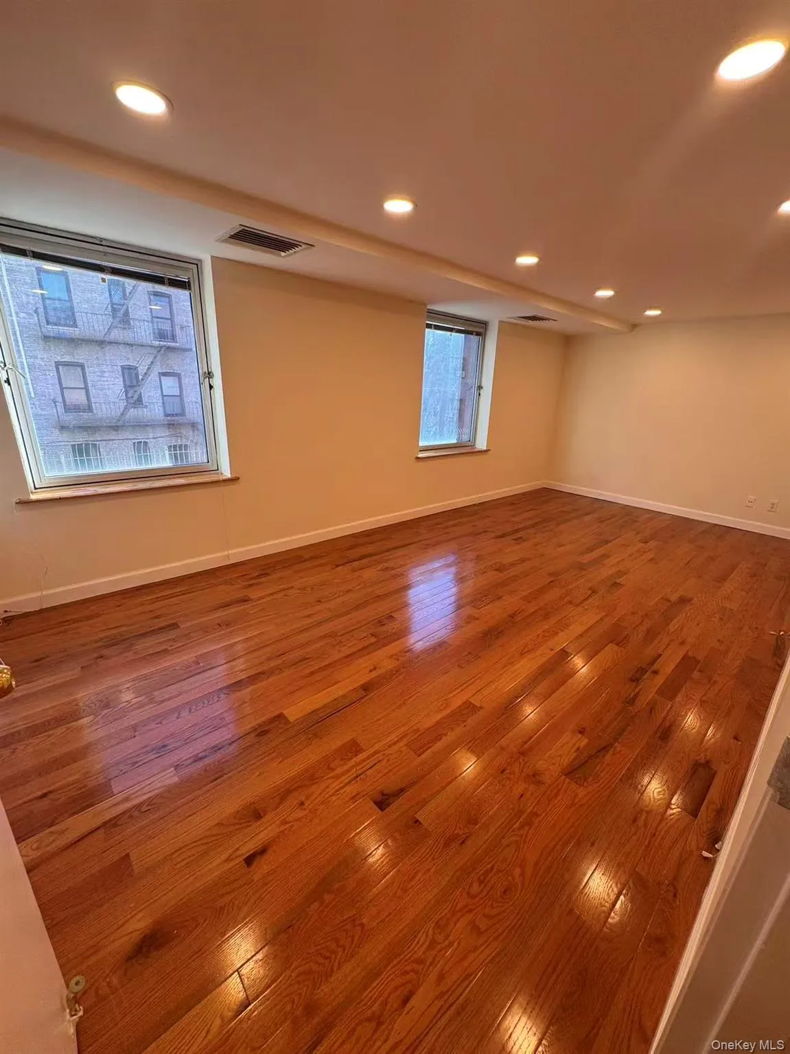 Empty room featuring wood-type flooring and recessed lighting Empty room featuring wood-type flooring and recessed lighting