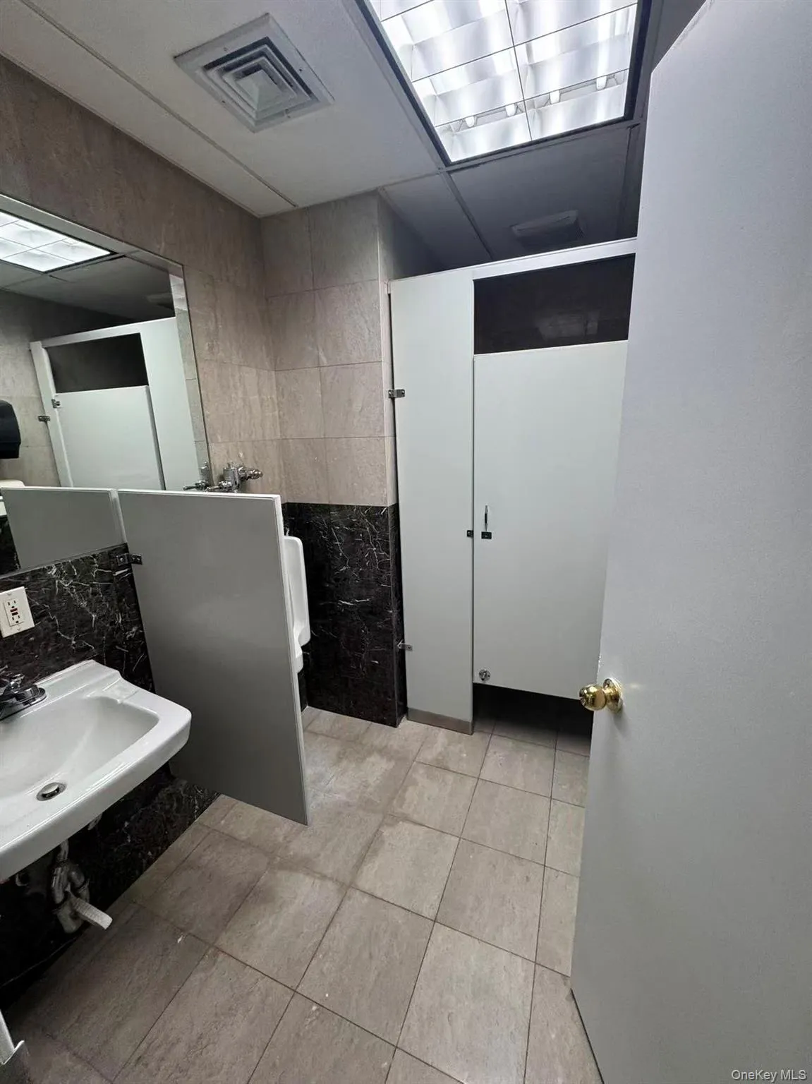 Bathroom featuring tile walls and a sink Bathroom featuring tile walls and a sink