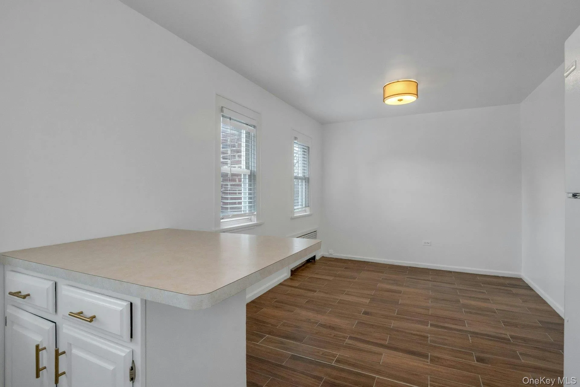 Unfurnished office featuring wood tiled floors and baseboards Unfurnished office featuring wood tiled floors and baseboards