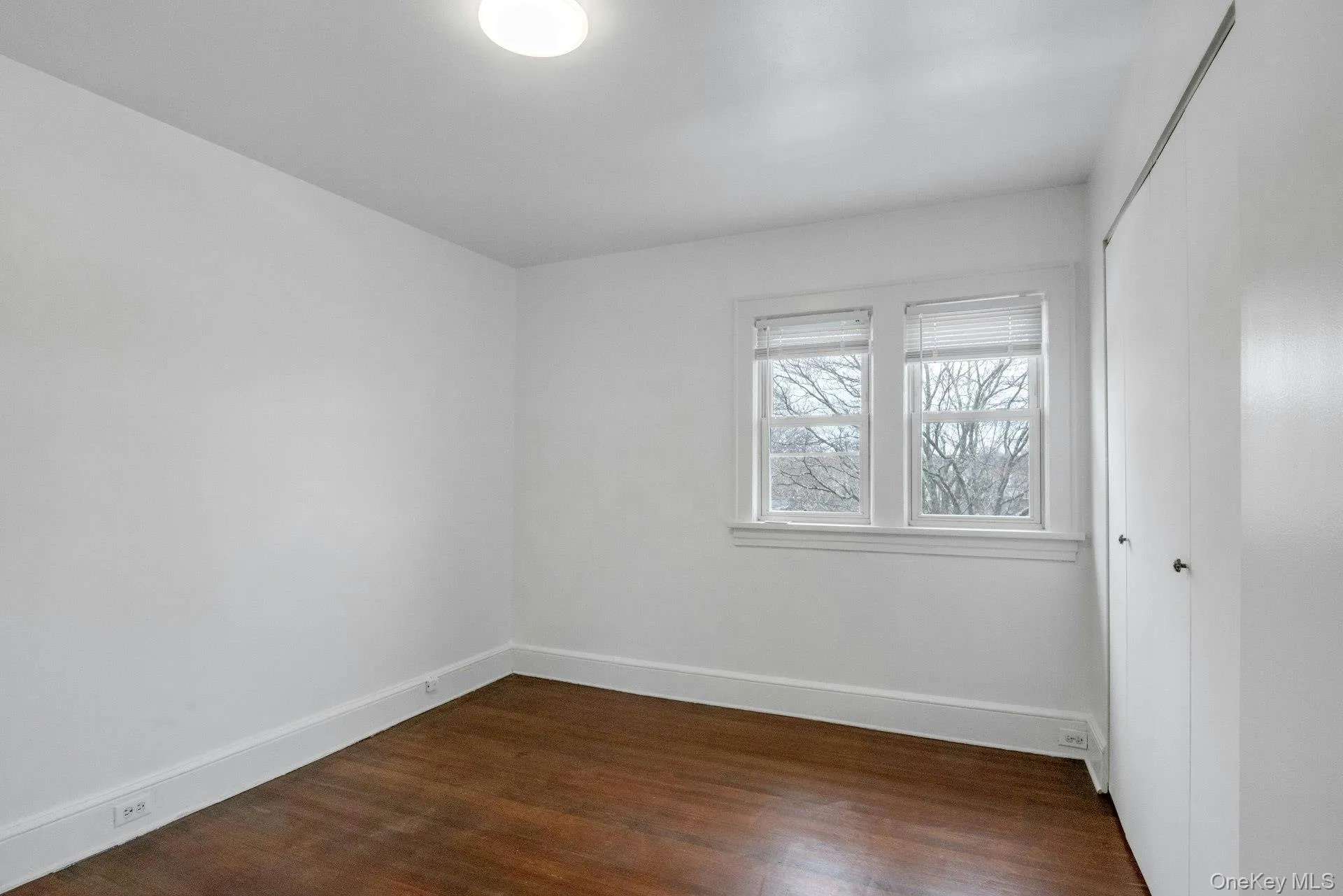 Empty room with dark wood finished floors and baseboards Empty room with dark wood finished floors and baseboards