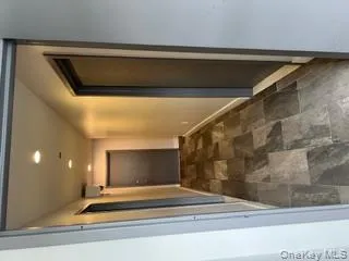 Hallway featuring recessed lighting and stone finish flooring Hallway featuring recessed lighting and stone finish flooring