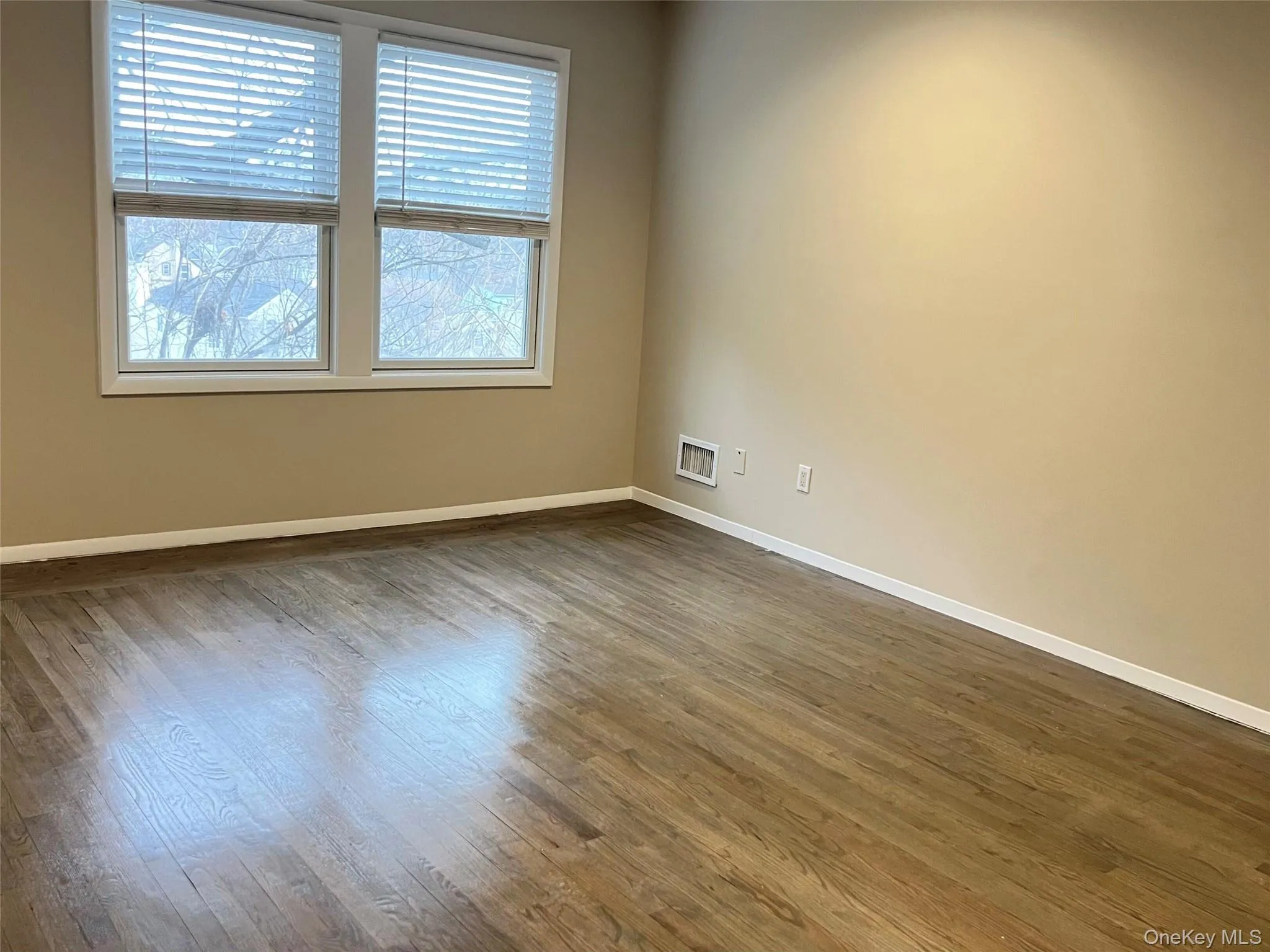 Empty room with wood finished floors and baseboards Empty room with wood finished floors and baseboards
