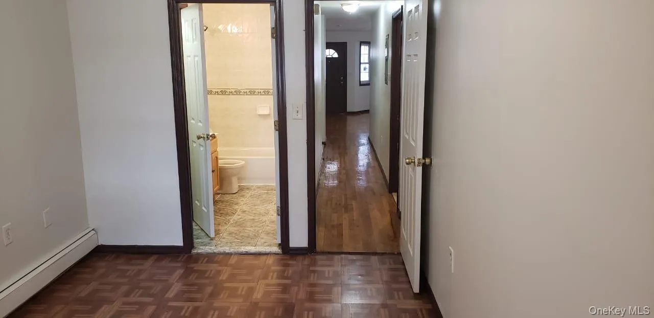 Hall featuring a baseboard radiator and parquet flooring Hall featuring a baseboard radiator and parquet flooring