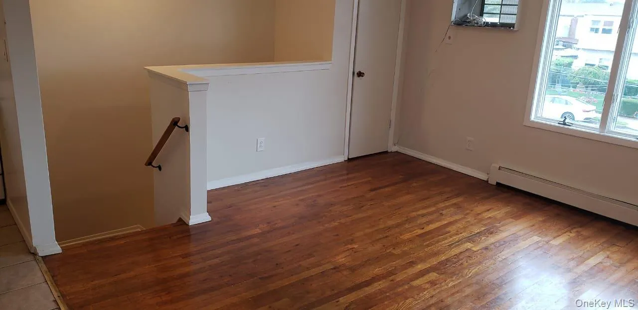 Spare room featuring hardwood / wood-style flooring and baseboards Spare room featuring hardwood / wood-style flooring and baseboards