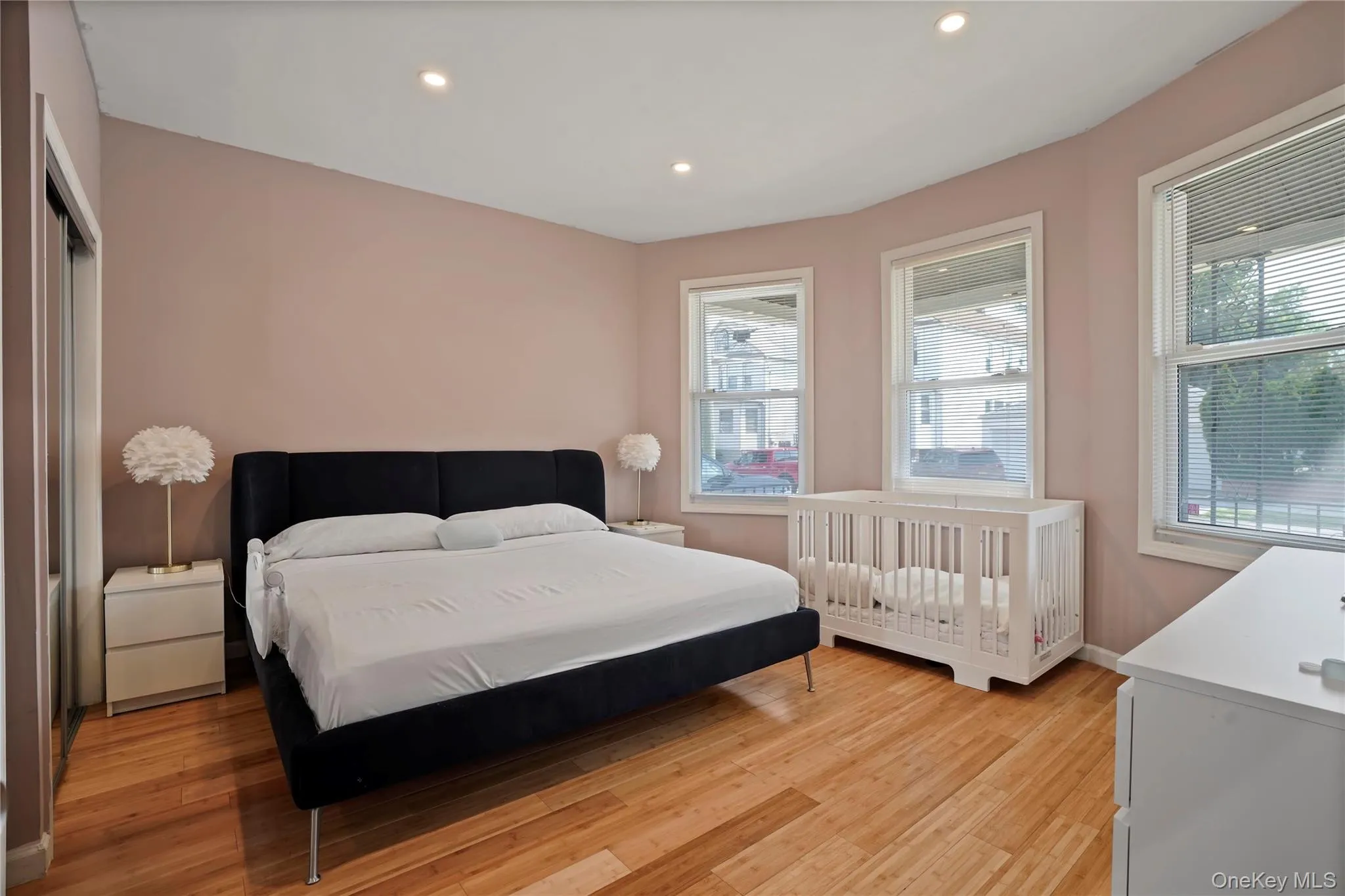 Bedroom with light wood-type flooring, recessed lighting, and multiple windows Bedroom with light wood-type flooring, recessed lighting, and multiple windows
