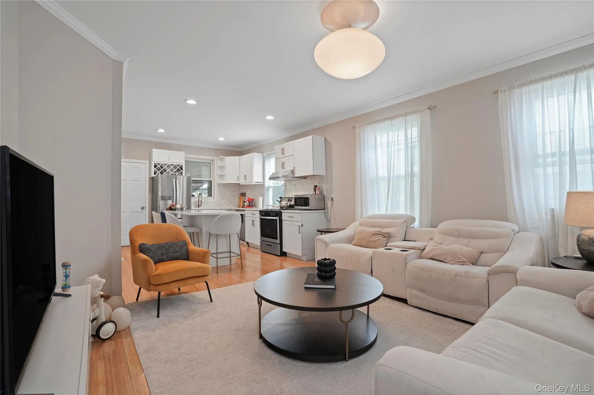Living area with crown molding, light wood-style floors, and recessed lighting Living area with crown molding, light wood-style floors, and recessed lighting