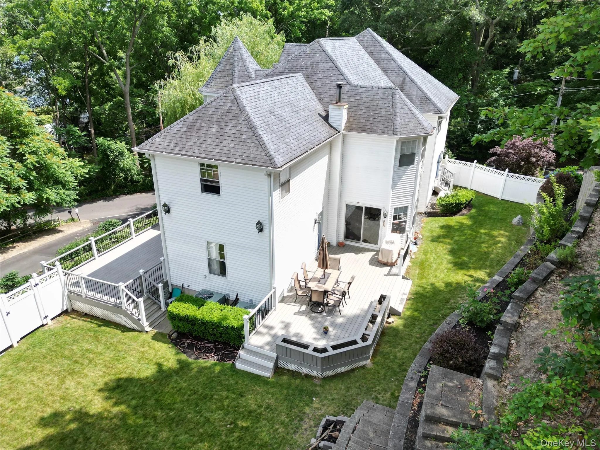 Rear view of property with a fenced backyard, a deck, outdoor dining space, and a shingled roof Rear view of property with a fenced backyard, a deck, outdoor dining space, and a shingled roof