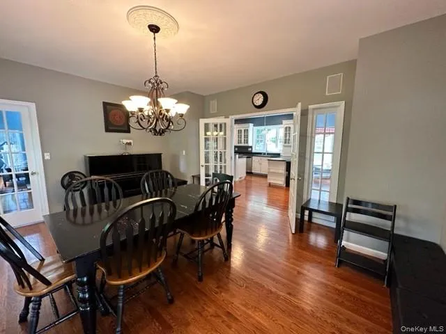 Dining space with wood finished floors and a chandelier Dining space with wood finished floors and a chandelier