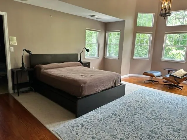 Bedroom featuring wood finished floors and a chandelier Bedroom featuring wood finished floors and a chandelier