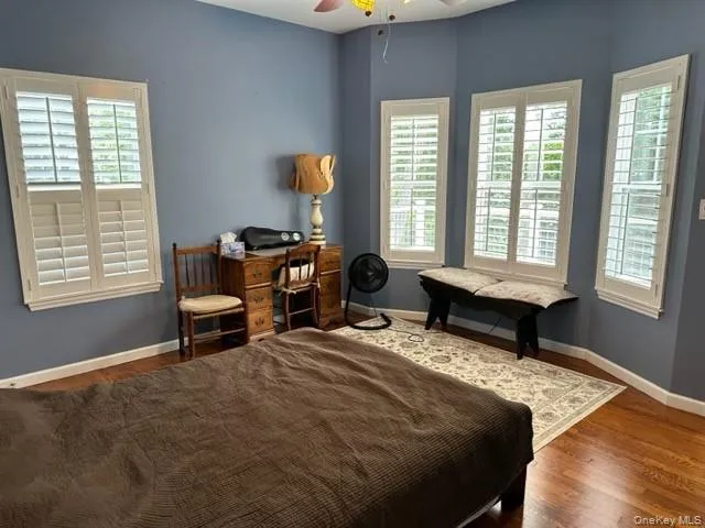 Bedroom with wood finished floors and a ceiling fan Bedroom with wood finished floors and a ceiling fan