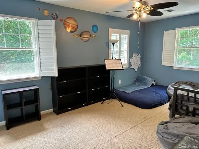 Carpeted bedroom with a ceiling fan and baseboards Carpeted bedroom with a ceiling fan and baseboards