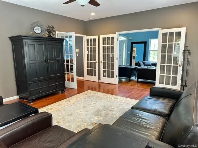 Living room featuring french doors, wood finished floors, and ceiling fan Living room featuring french doors, wood finished floors, and ceiling fan