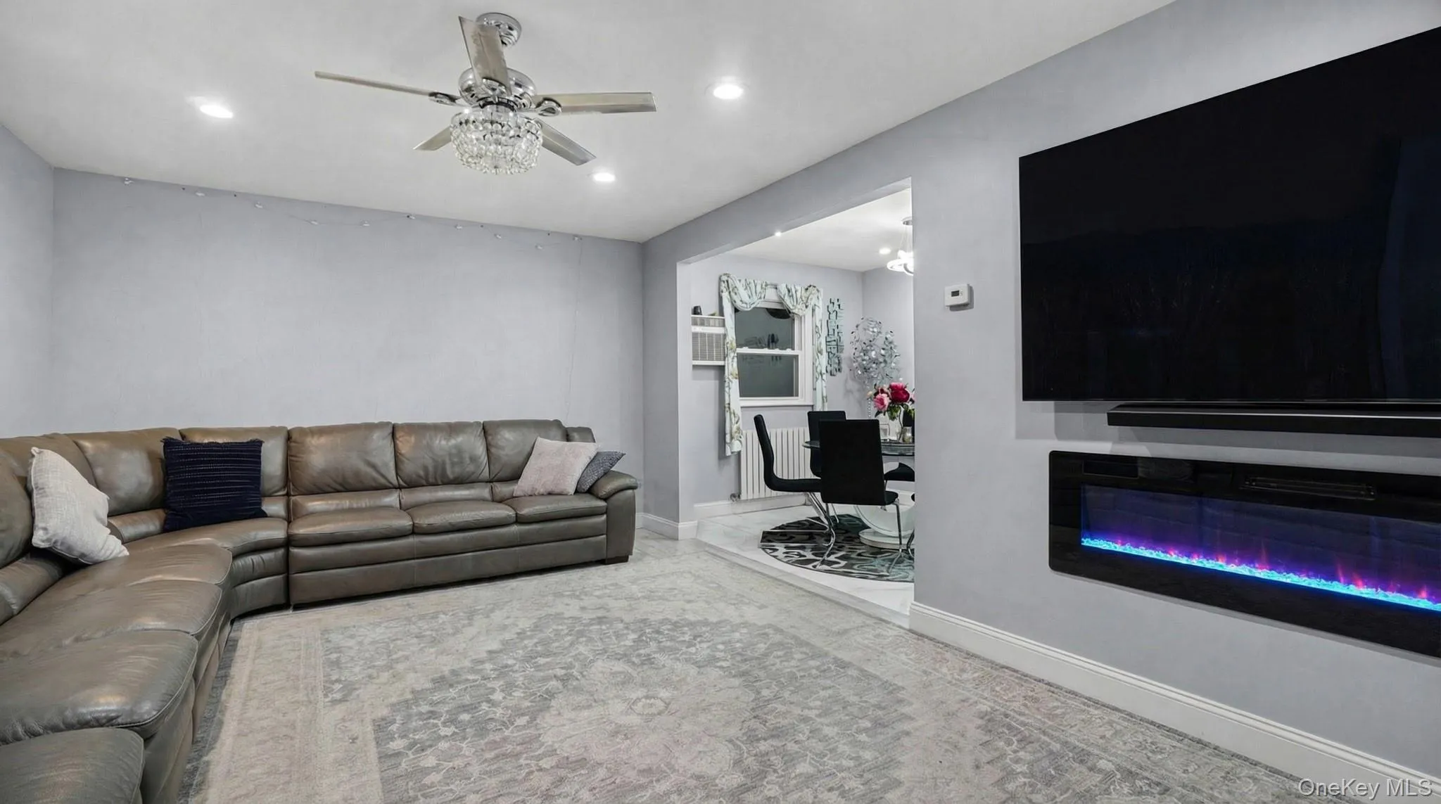 Living room with a glass covered fireplace, recessed lighting, and ceiling fan Living room with a glass covered fireplace, recessed lighting, and ceiling fan