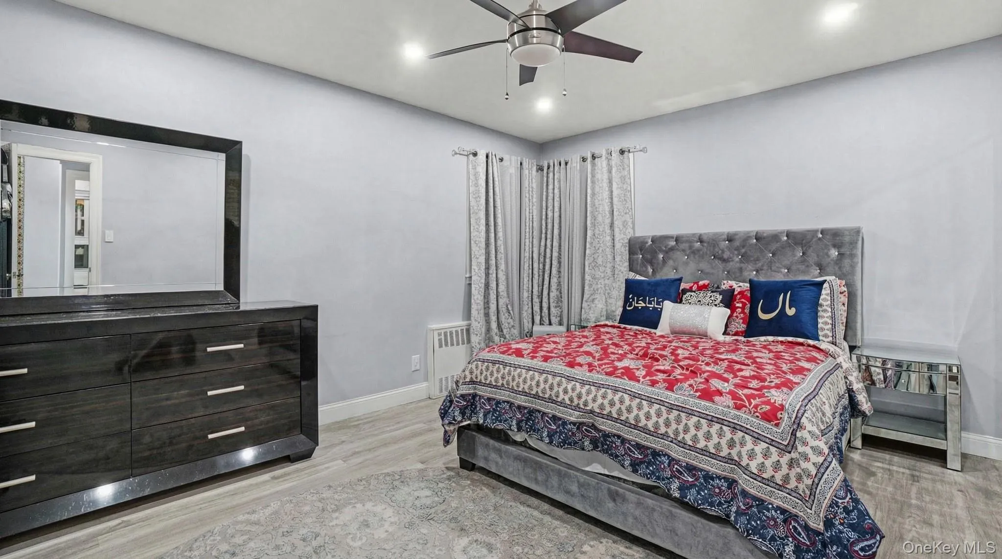 Bedroom with radiator heating unit, light wood-style floors, and ceiling fan Bedroom with radiator heating unit, light wood-style floors, and ceiling fan