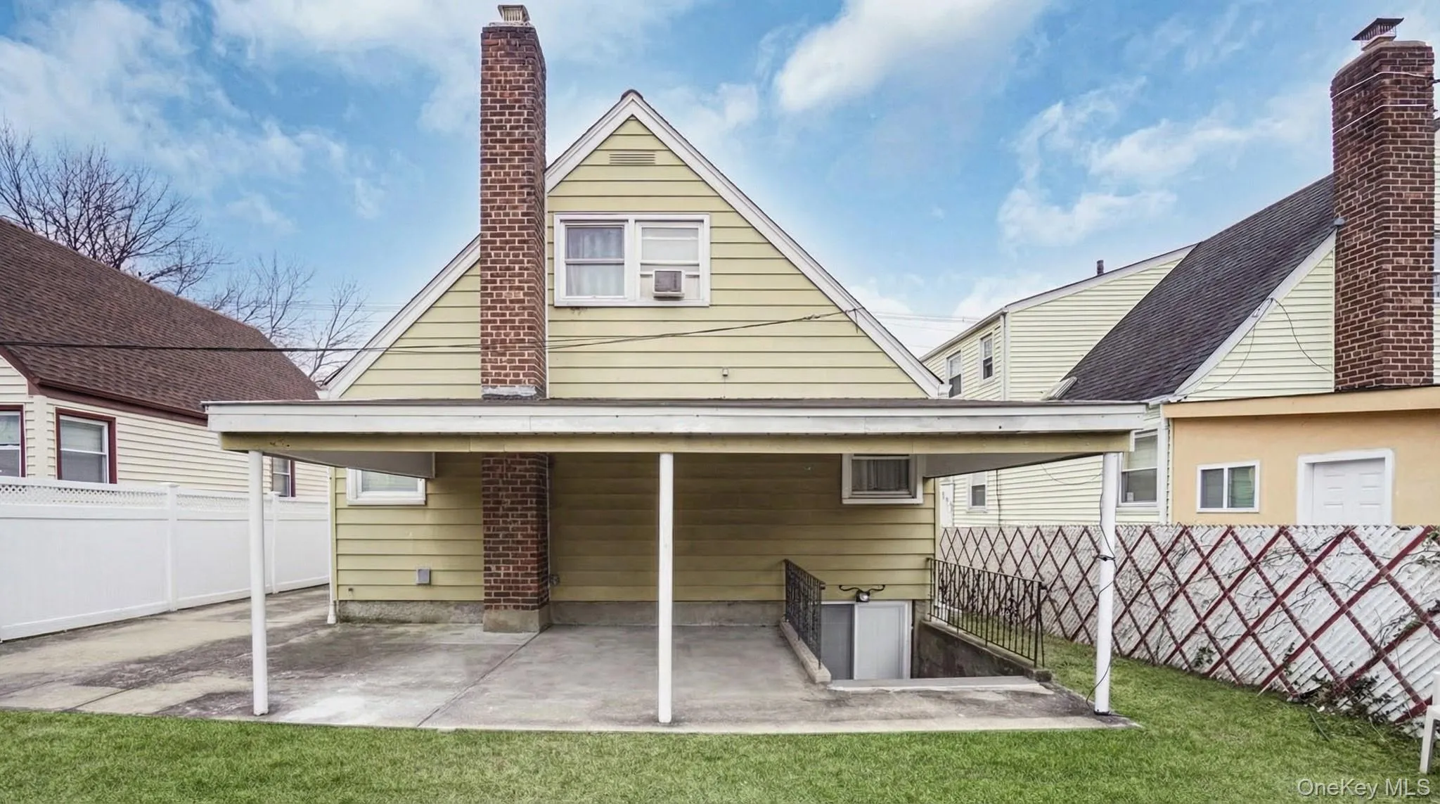 Back of house featuring a fenced backyard, a patio area, and a chimney Back of house featuring a fenced backyard, a patio area, and a chimney