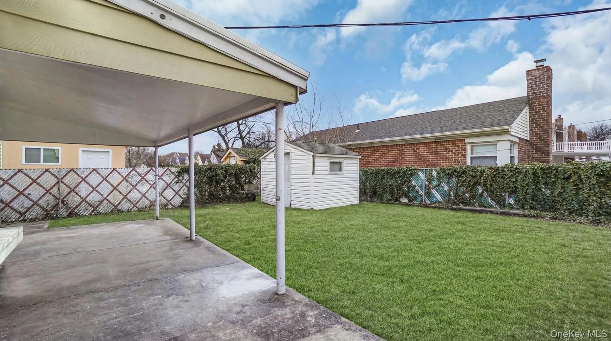 Fenced backyard with a storage shed and a patio Fenced backyard with a storage shed and a patio