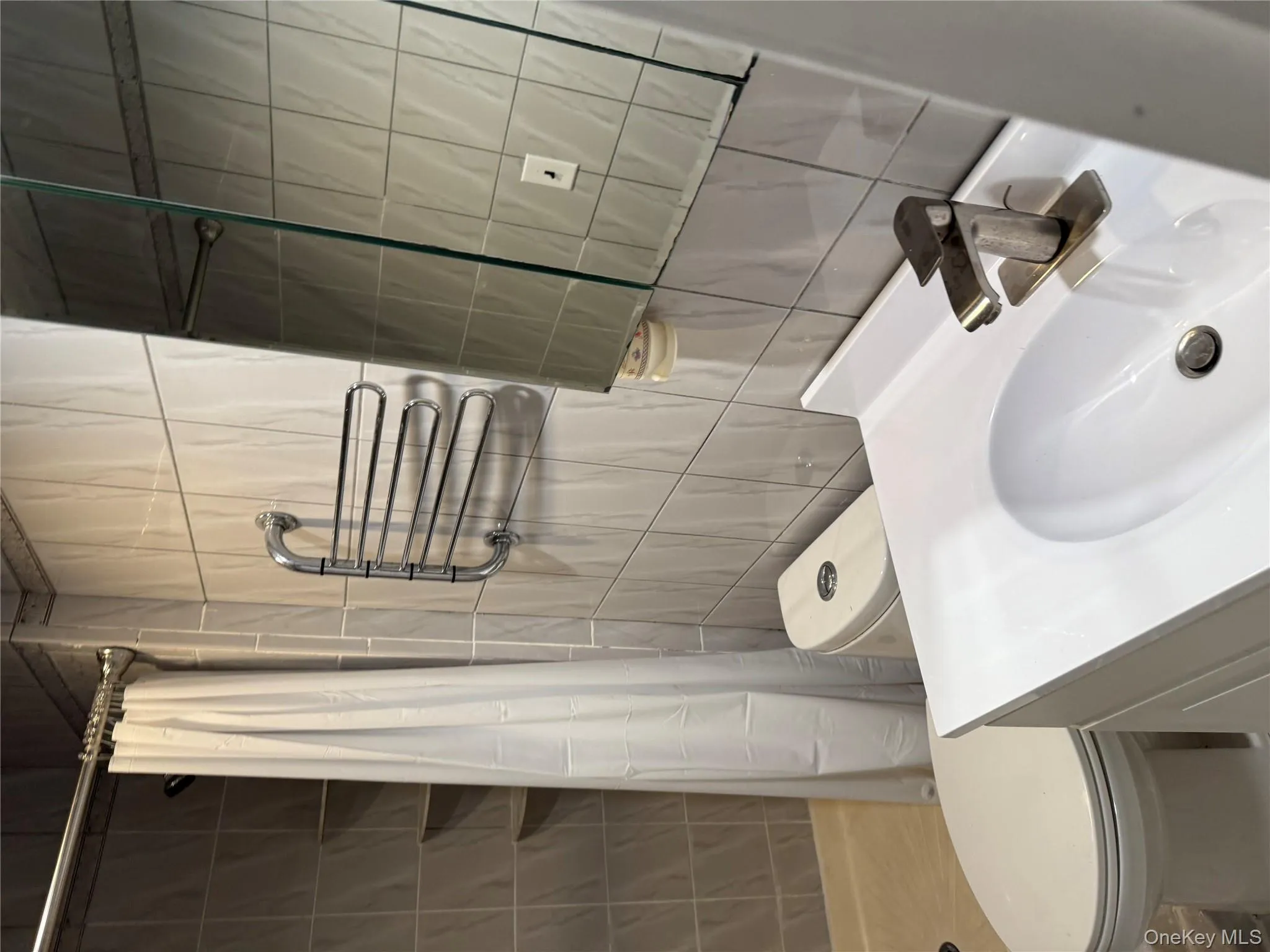 Bathroom featuring vanity, a stall shower, and tile walls Bathroom featuring vanity, a stall shower, and tile walls