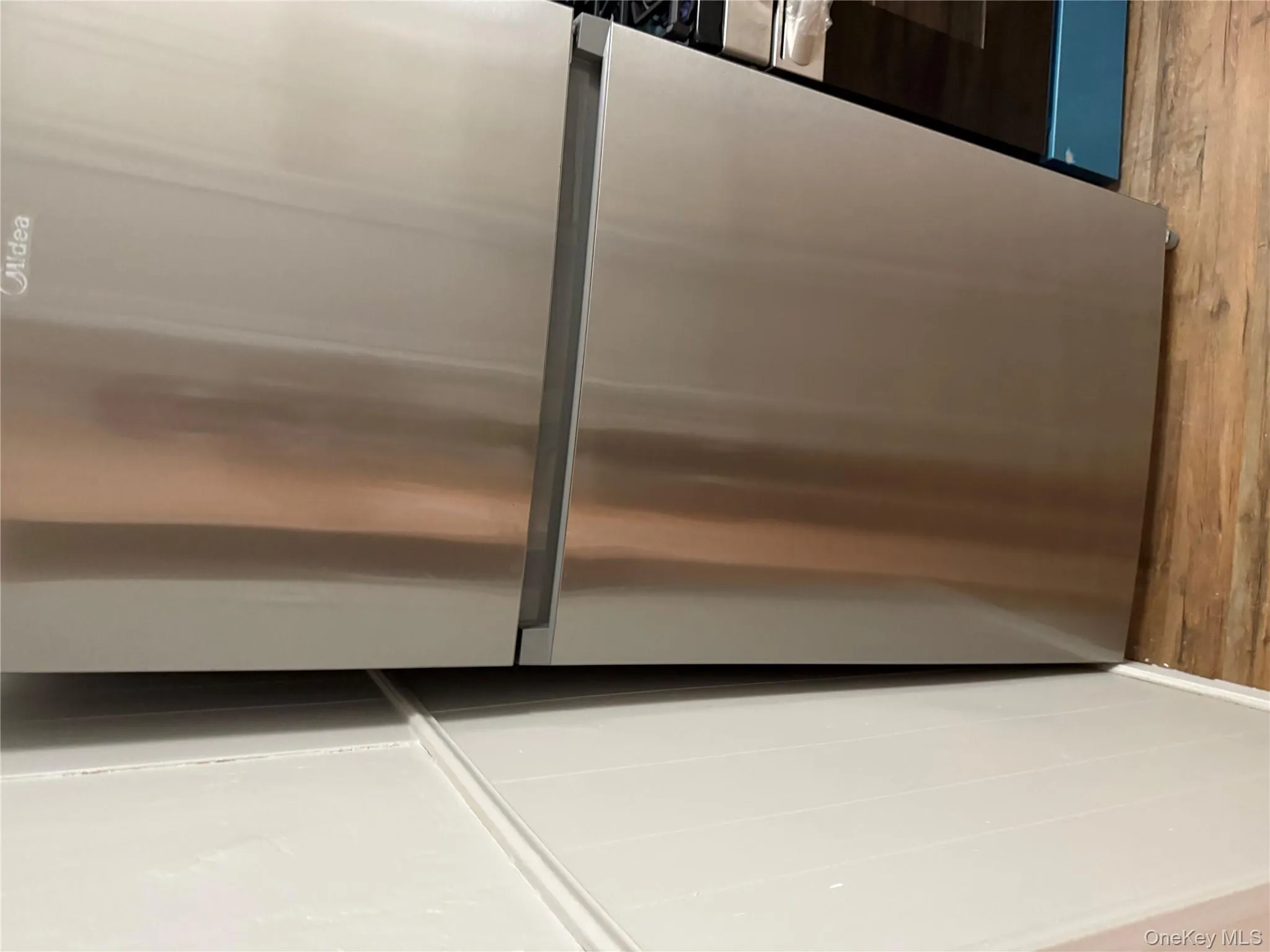 Kitchen view of appliances with stainless steel finishes and light wood-type flooring Kitchen view of appliances with stainless steel finishes and light wood-type flooring