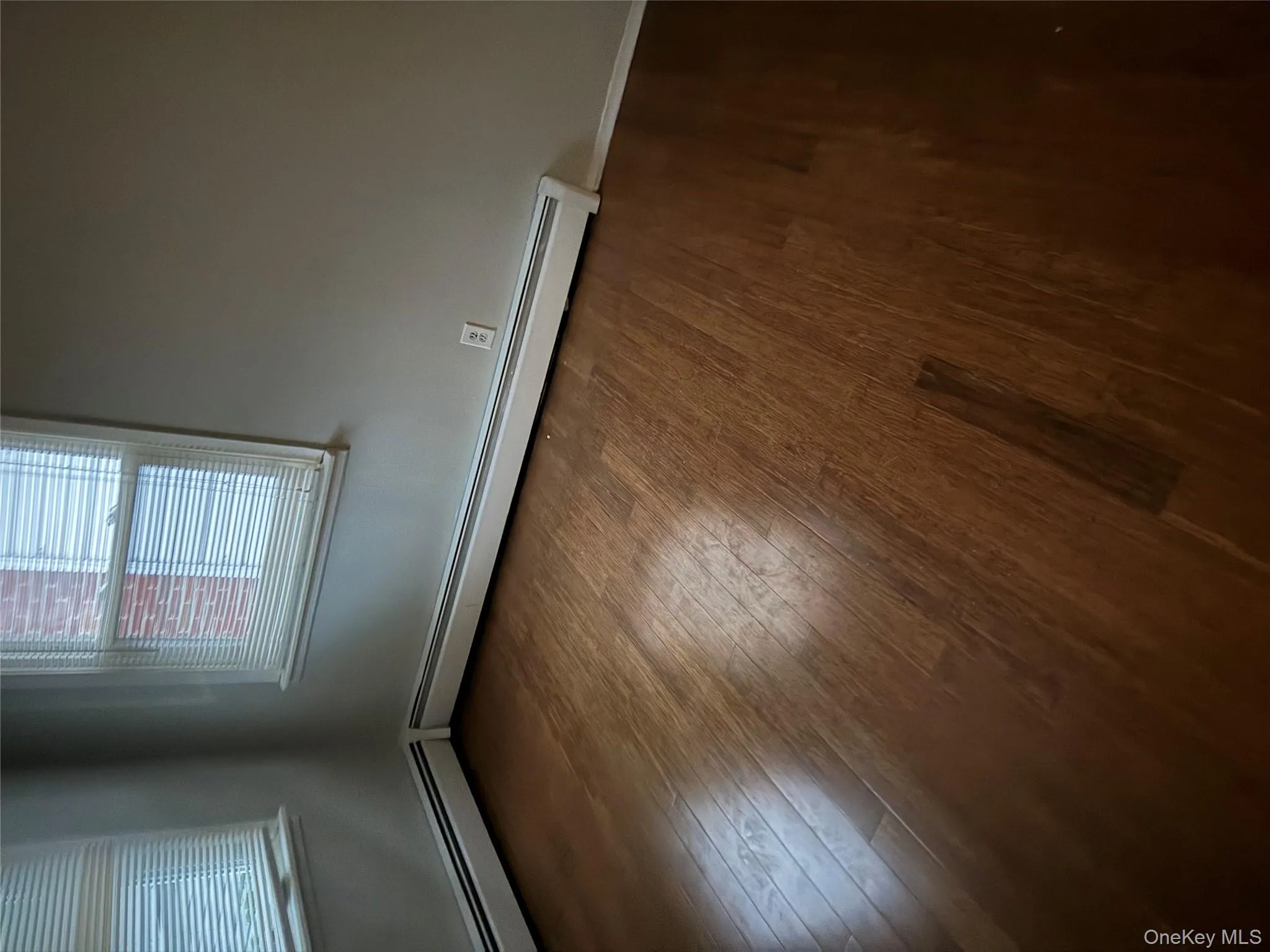 Empty room featuring a baseboard heating unit and dark wood finished floors Empty room featuring a baseboard heating unit and dark wood finished floors