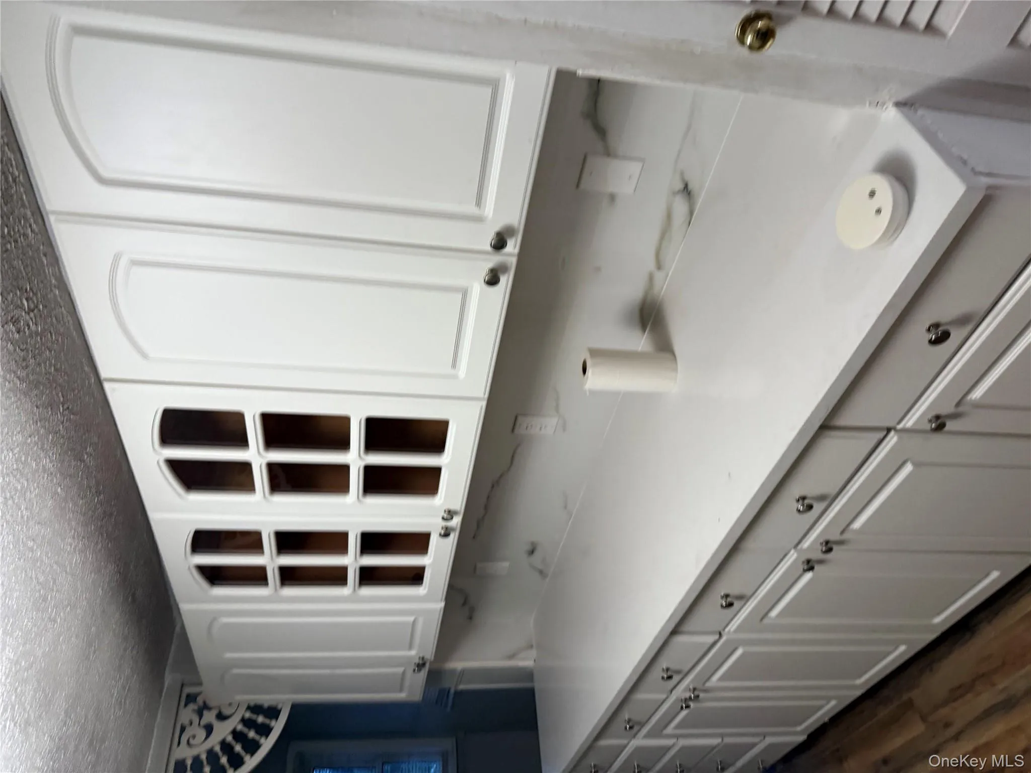 Kitchen with white cabinets, a textured ceiling, and dark wood-type flooring Kitchen with white cabinets, a textured ceiling, and dark wood-type flooring