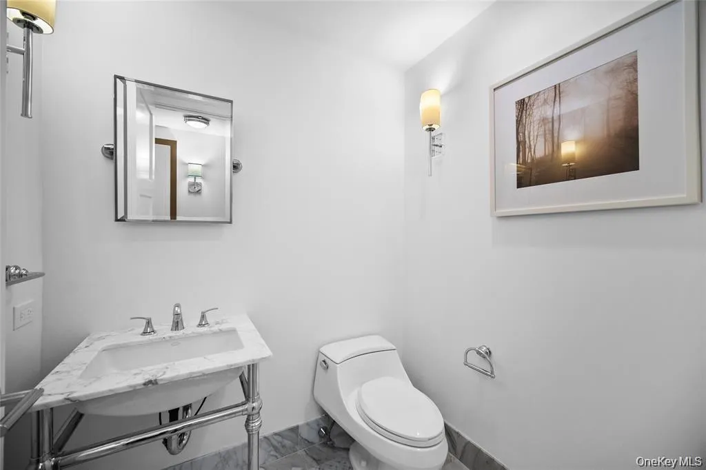 Half bath featuring marble finish flooring and toilet Half bath featuring marble finish flooring and toilet