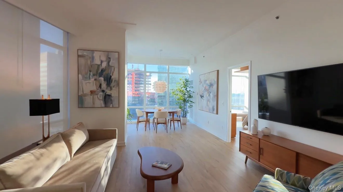 Living area featuring light wood-style floors and floor to ceiling windows Living area featuring light wood-style floors and floor to ceiling windows