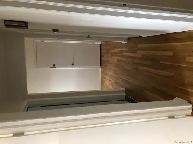 Hallway featuring dark wood-style flooring and baseboards Hallway featuring dark wood-style flooring and baseboards