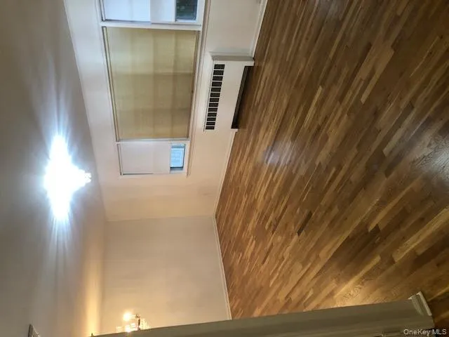 Spare room with a chandelier, dark wood-style floors, and radiator Spare room with a chandelier, dark wood-style floors, and radiator