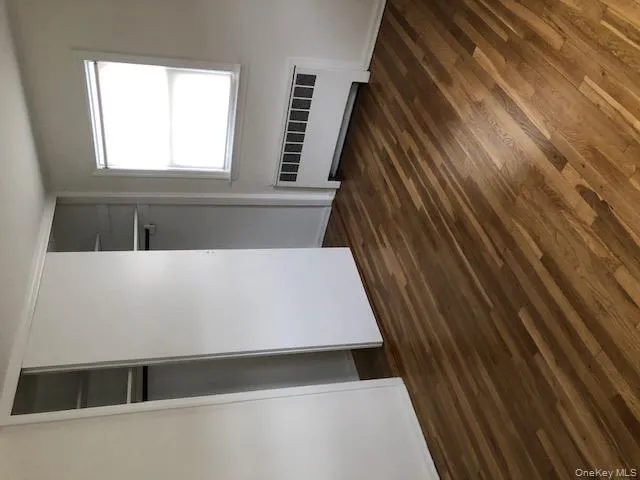 Unfurnished bedroom with radiator, dark wood-style floors, and a closet Unfurnished bedroom with radiator, dark wood-style floors, and a closet