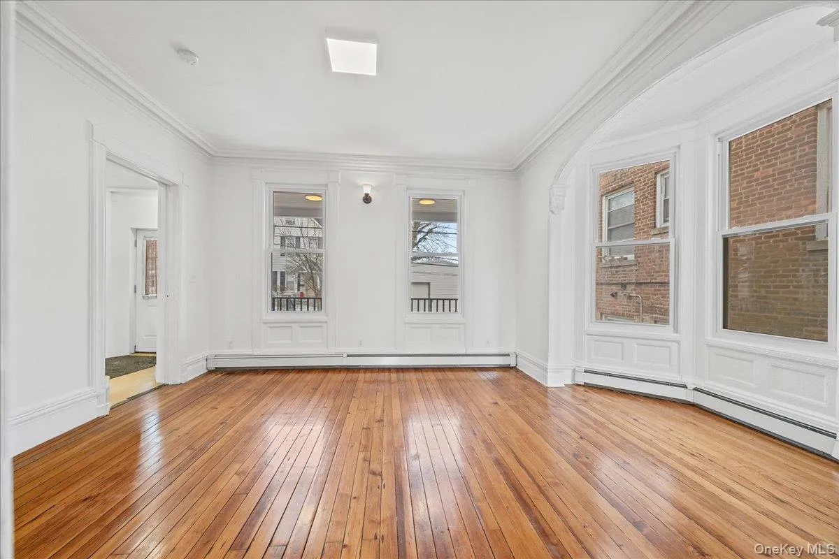 Spare room featuring light wood finished floors, baseboard heating, crown molding, and a baseboard heating unit Spare room featuring light wood finished floors, baseboard heating, crown molding, and a baseboard heating unit