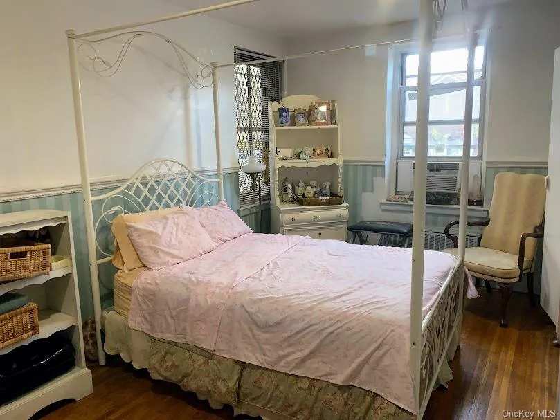Bedroom featuring wainscoting, dark wood-style flooring, and cooling unit Bedroom featuring wainscoting, dark wood-style flooring, and cooling unit
