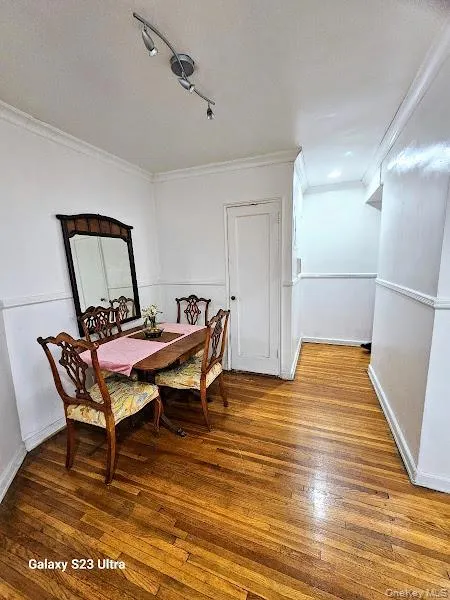 Dining area featuring ornamental molding, hardwood / wood-style floors, and a textured ceiling Dining area featuring ornamental molding, hardwood / wood-style floors, and a textured ceiling