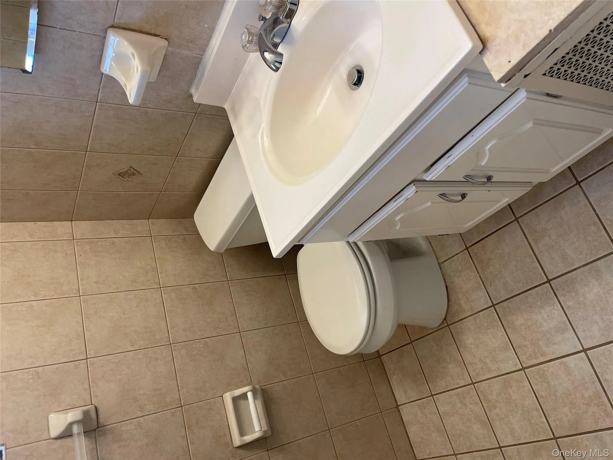 Half bathroom featuring vanity, tile walls, and light tile patterned floors Half bathroom featuring vanity, tile walls, and light tile patterned floors