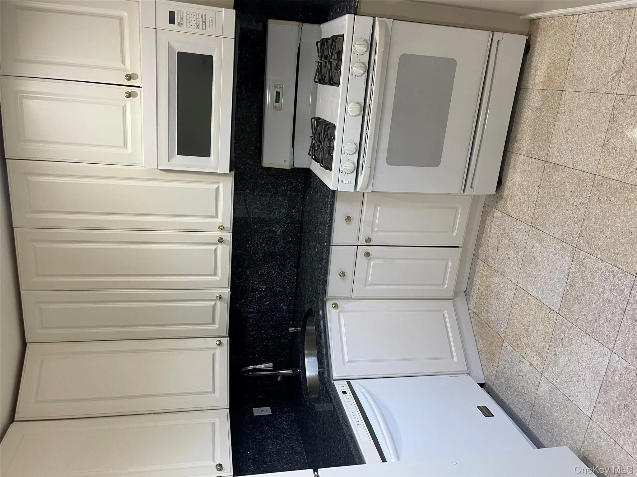 Kitchen with white range oven, white cabinetry, dark stone counters, decorative backsplash, and dishwasher Kitchen with white range oven, white cabinetry, dark stone counters, decorative backsplash, and dishwasher
