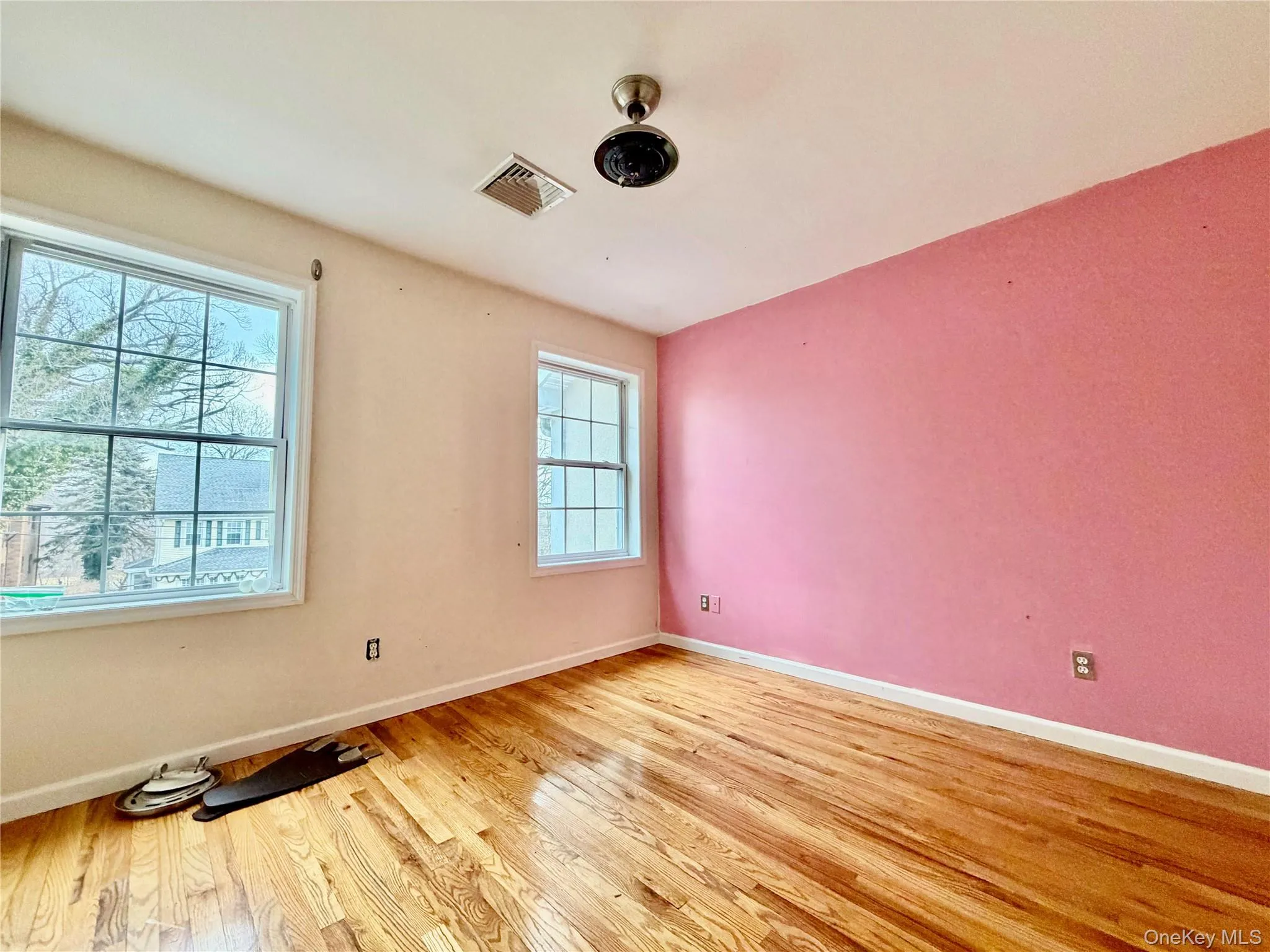 Empty room with light wood-style flooring and baseboards Empty room with light wood-style flooring and baseboards