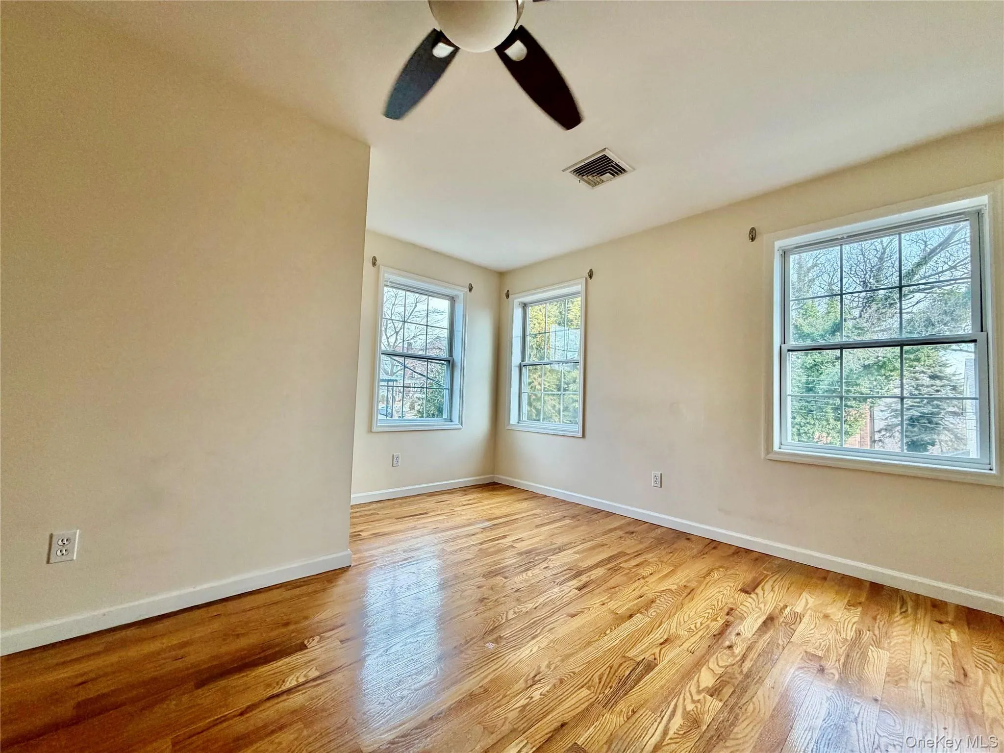 Empty room featuring light wood-style floors and ceiling fan Empty room featuring light wood-style floors and ceiling fan