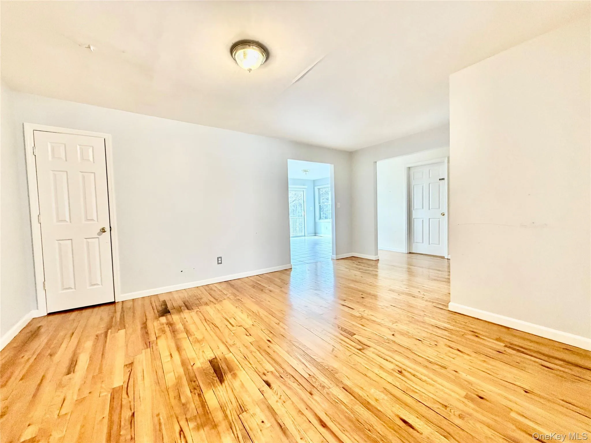 Empty room with light wood-type flooring and baseboards Empty room with light wood-type flooring and baseboards