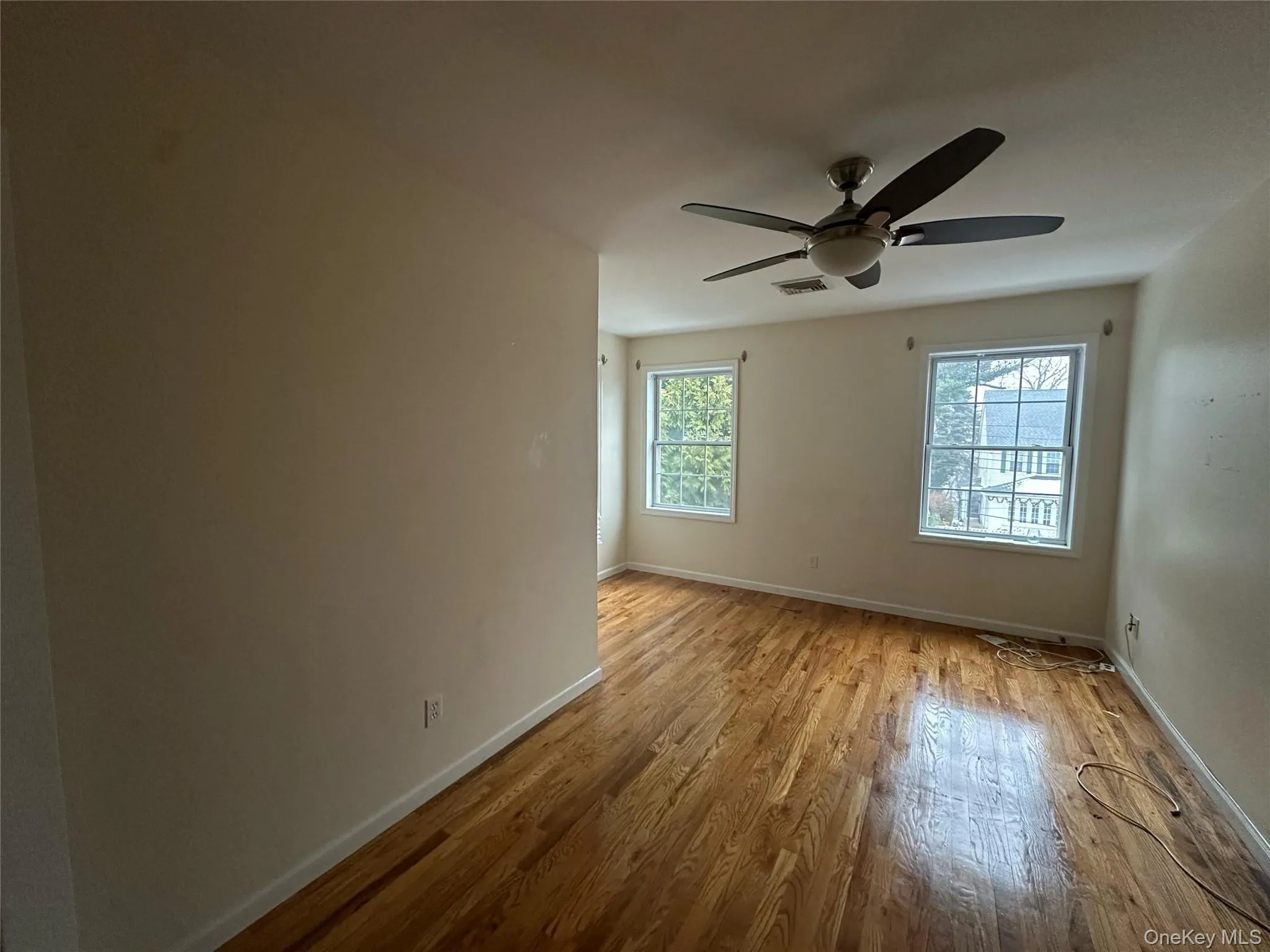 Empty room featuring light wood-type flooring and ceiling fan Empty room featuring light wood-type flooring and ceiling fan