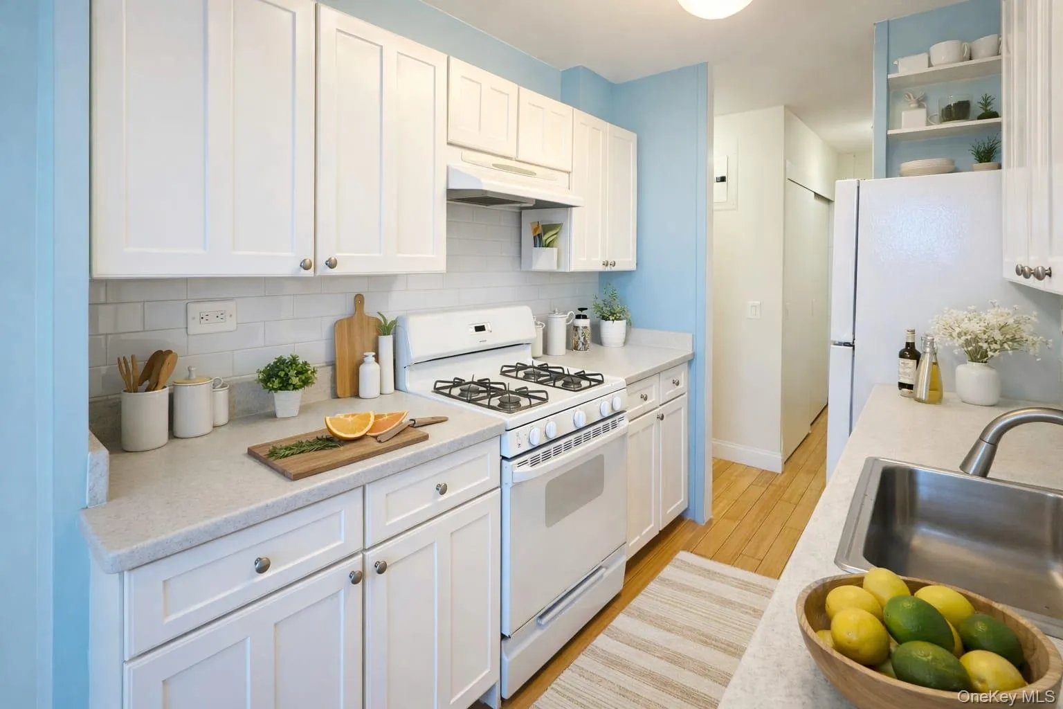 Kitchen featuring white appliances, white cabinets, open shelves, backsplash, and under cabinet range hood Kitchen featuring white appliances, white cabinets, open shelves, backsplash, and under cabinet range hood