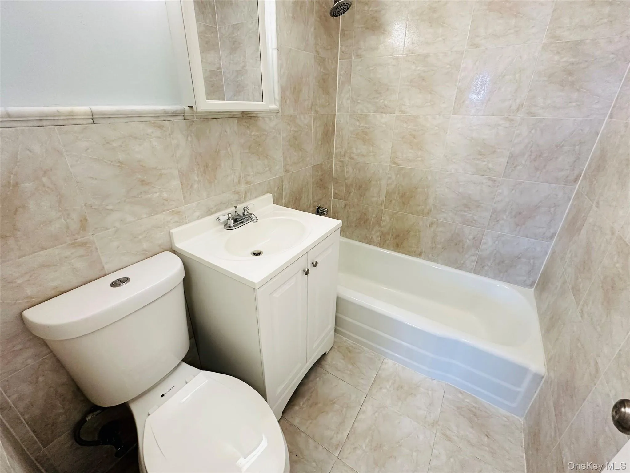 Full bath with tile walls, vanity, and shower / tub combination Full bath with tile walls, vanity, and shower / tub combination