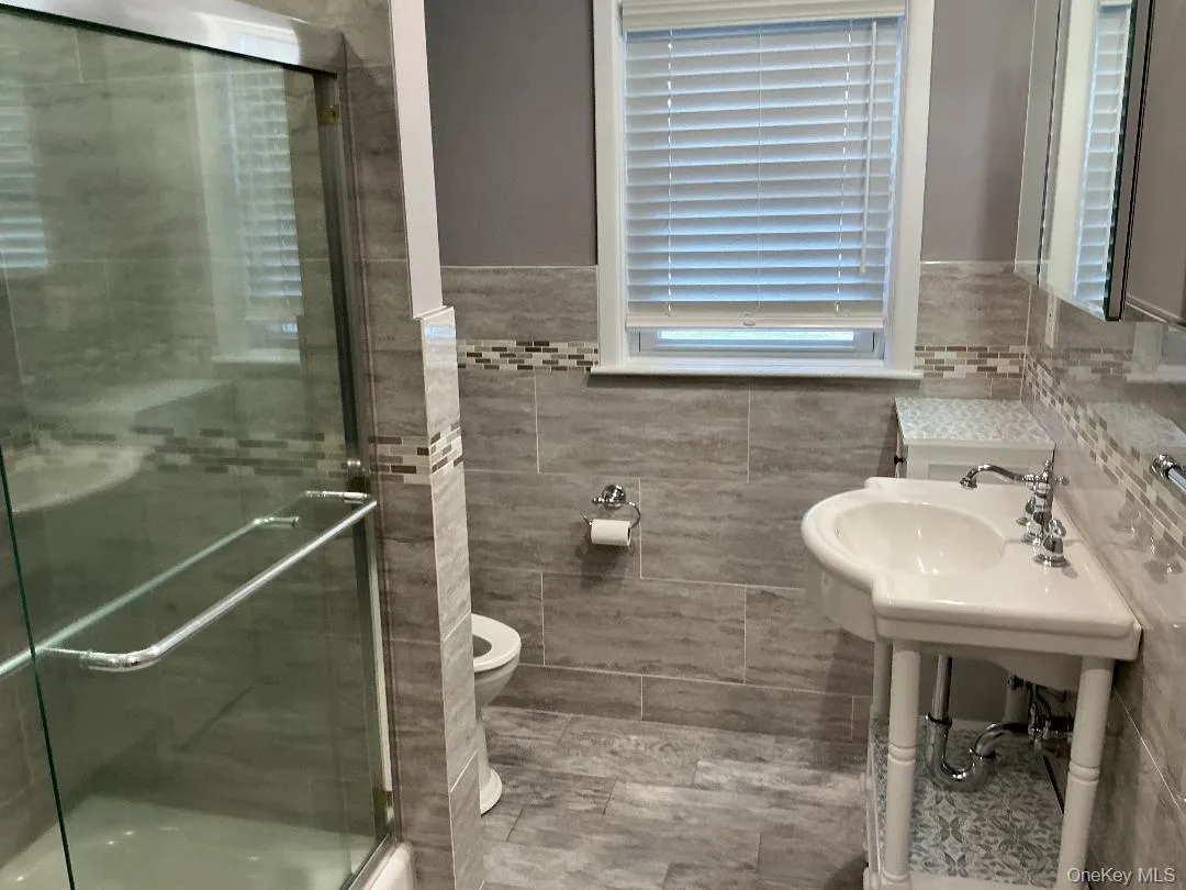 Bathroom with a stall shower and light tile patterned flooring Bathroom with a stall shower and light tile patterned flooring