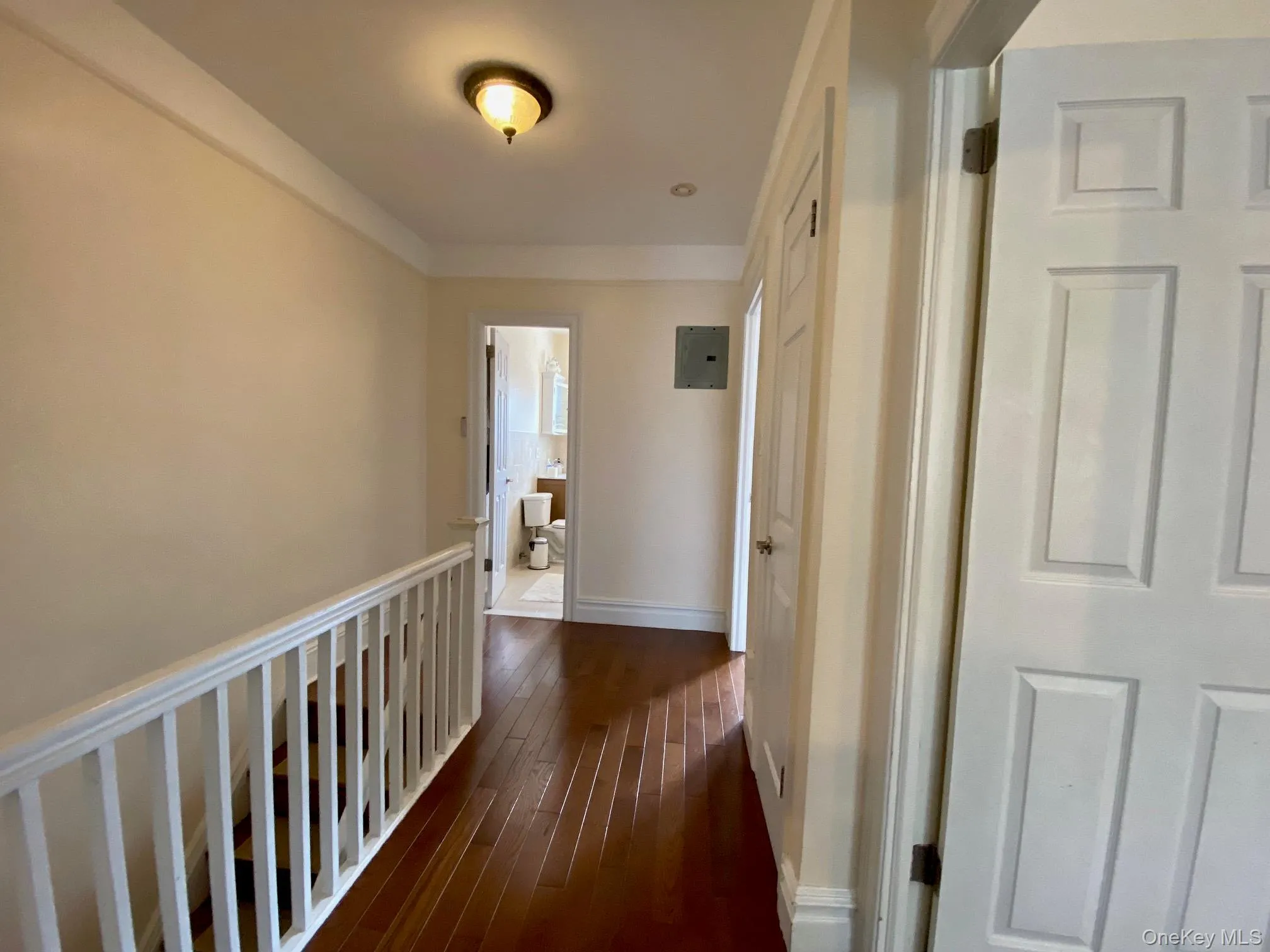 Hall featuring dark wood-style flooring and electric panel Hall featuring dark wood-style flooring and electric panel