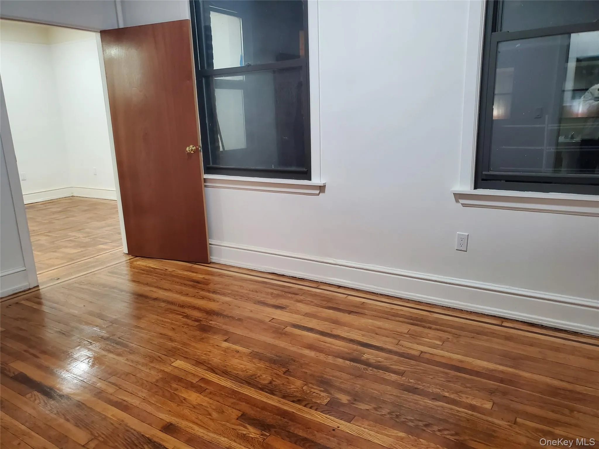 Empty room featuring wood-type flooring and baseboards Empty room featuring wood-type flooring and baseboards