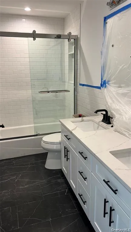 Bathroom with double vanity and combined bath / shower with glass door Bathroom with double vanity and combined bath / shower with glass door