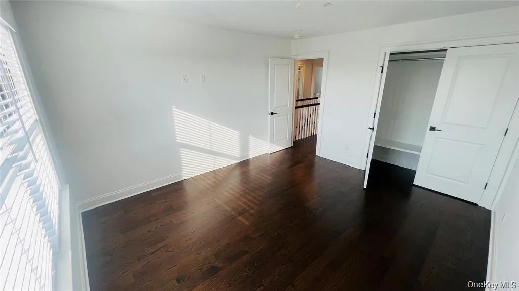Unfurnished bedroom featuring a closet and dark wood-type flooring Unfurnished bedroom featuring a closet and dark wood-type flooring
